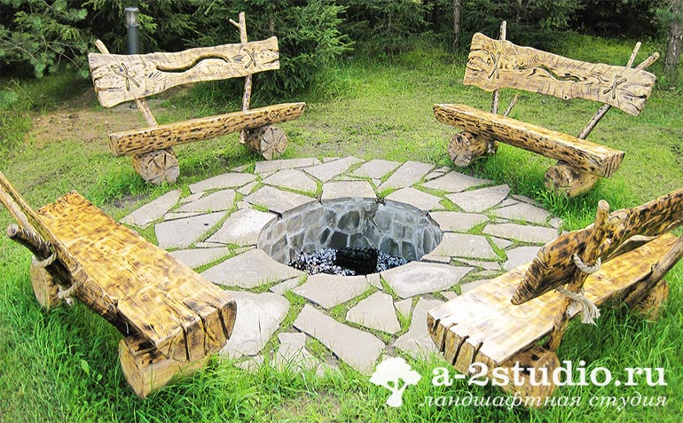 Rest area with a fireplace and benches made of logs
